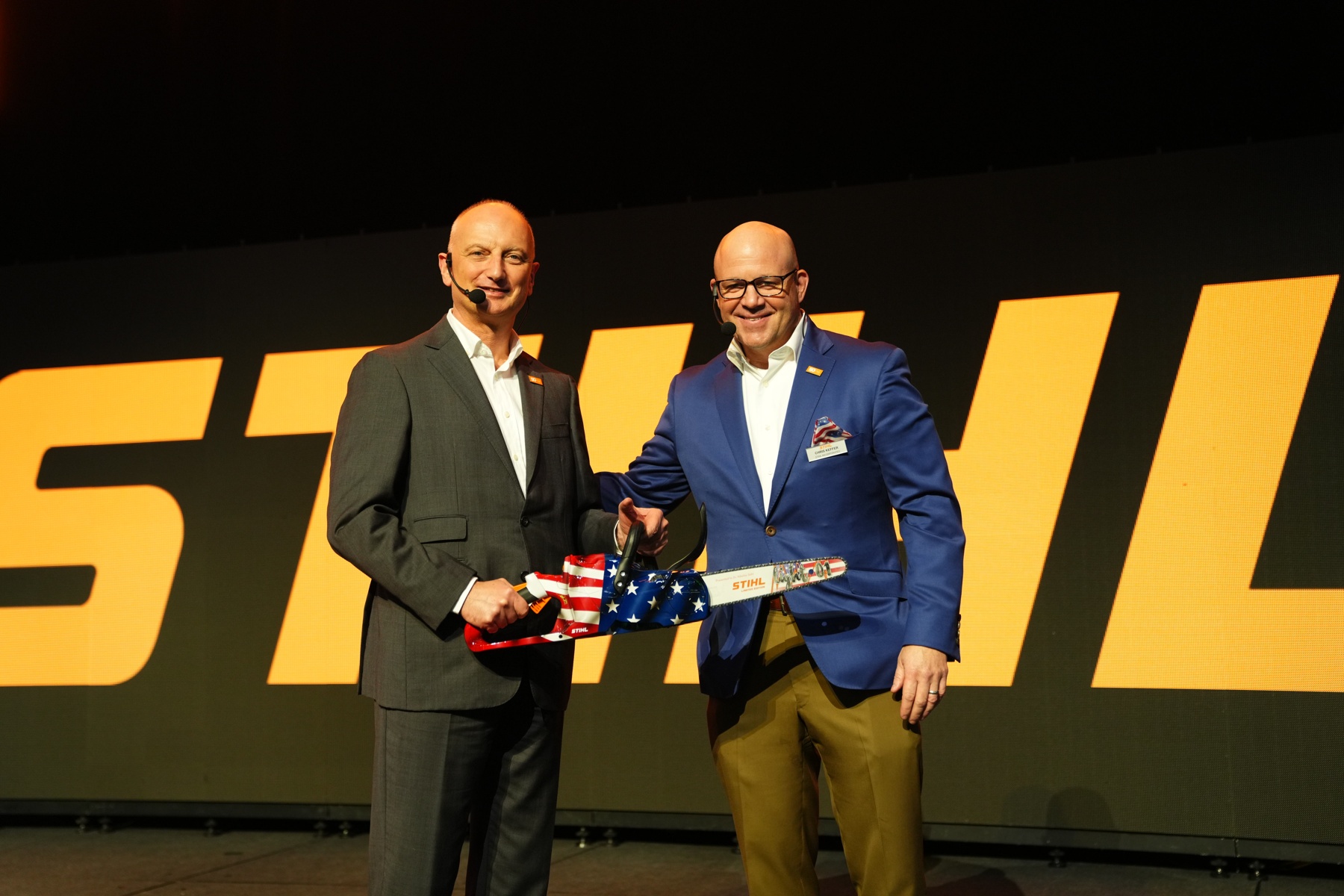 Dr. Nikolas Stihl (left) and Chris Keffer, Managing Director of STIHL Inc. in the USA, present an anniversary saw with a US flag.